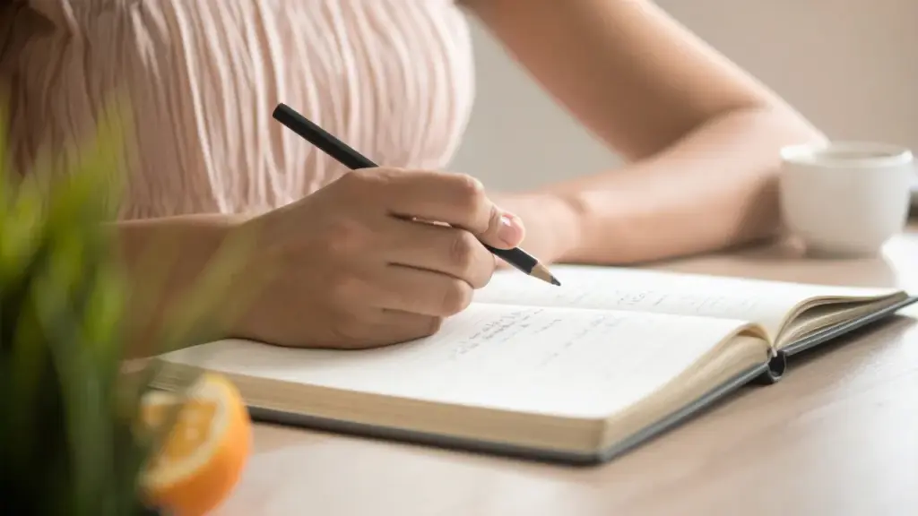 ノートに感情を書き出す女性